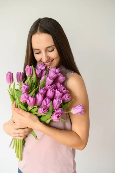 L'umore primaverile. Bella donna con tulipani al chiuso — Foto Stock
