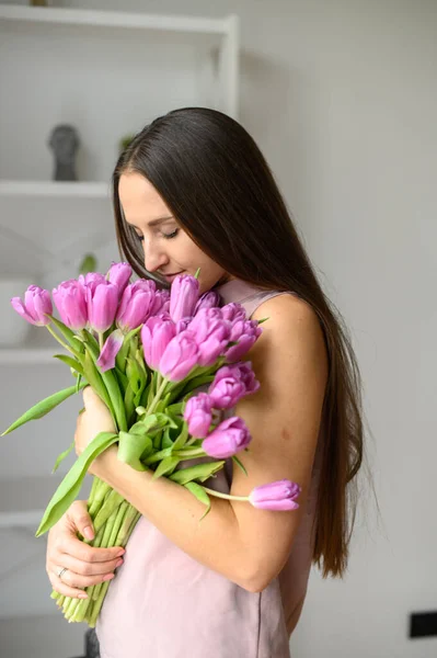 Humor de primavera. Mujer hermosa con tulipanes en el interior — Foto de Stock