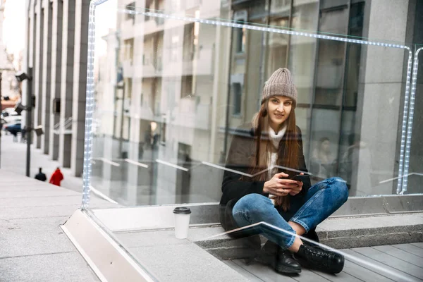 Jovem menina atraente está digitando uma mensagem no telefone — Fotografia de Stock