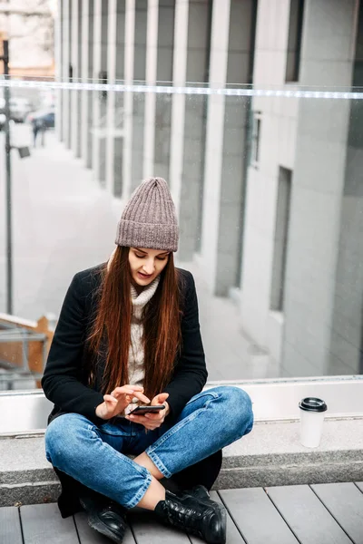 Giovane ragazza attraente sta digitando un messaggio al telefono — Foto Stock