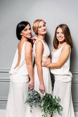 Stüdyoda zarif beyaz elbiseli nedimeler.