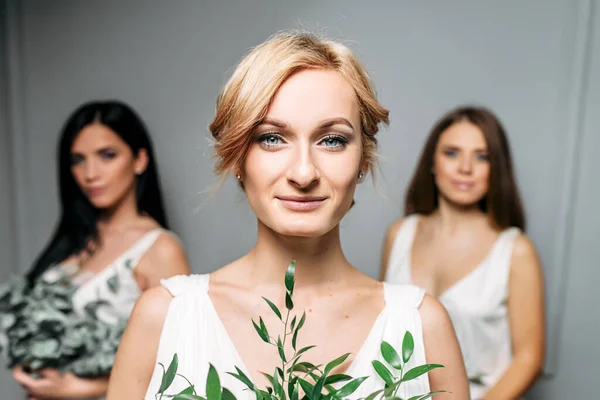 Dama de honra em elegantes vestidos brancos no estúdio — Fotografia de Stock