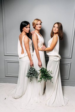 Stüdyoda zarif beyaz elbiseli nedimeler.