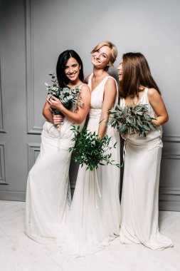 Stüdyoda zarif beyaz elbiseli nedimeler.