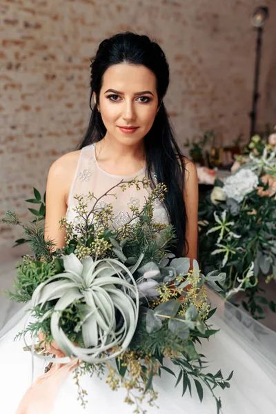 Een charmante en tedere bruid met een boeket — Stockfoto