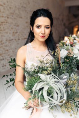 Bir buketi olan çekici ve narin bir gelin.