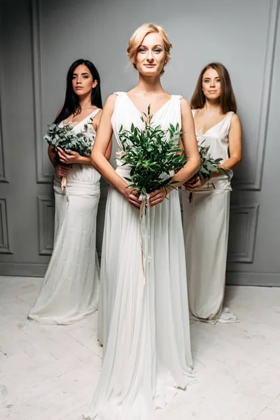 Bridesmaids in elegant white dresses in the studio