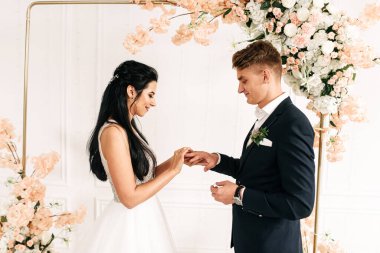 Yeni evliler birbirlerinin parmaklarına yüzük takarlar.