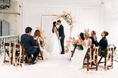 Düğün kemerinin yanında bir çift gelin ve damat