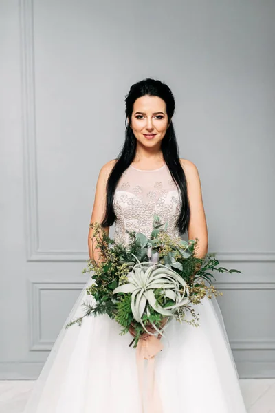 Mooie bruid met een boeket groene takken — Stockfoto