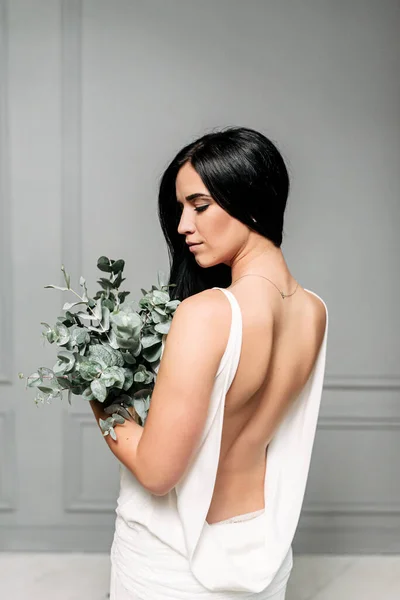 Novia en un vestido largo blanco con una espalda desnuda . — Foto de Stock