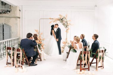 Düğün kemerinin yanında bir çift gelin ve damat