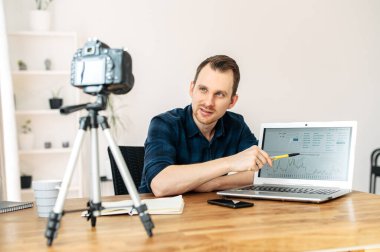Genç adam video dersleri veriyor ve kaydediyor.