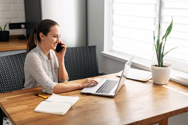 Mujer joven trabaja desde casa utilizando el ordenador portátil . — Foto de Stock