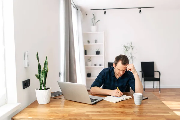 Jongeman die thuis werkt met laptop. — Stockfoto