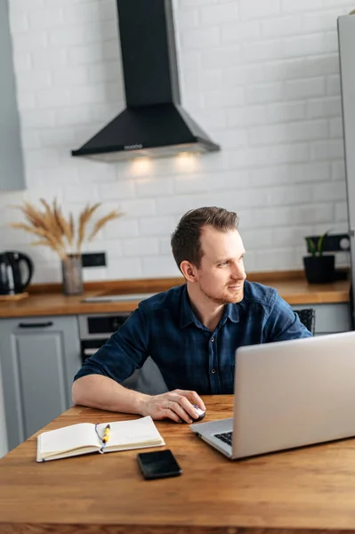 Fiatal férfi dolgozik otthonról laptoppal. — Stock Fotó