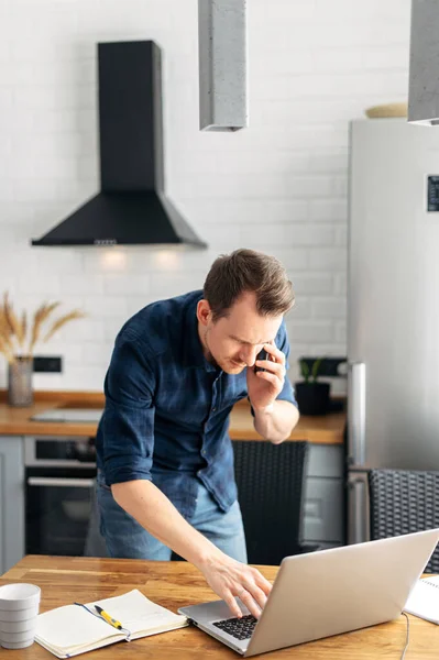 Young man working from home using laptop.