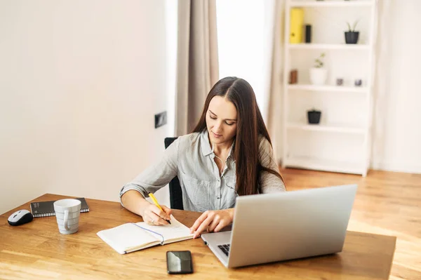 Mujer joven trabaja desde casa utilizando el ordenador portátil . —  Fotos de Stock