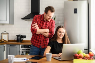 Genç bir aile yeni bir evde online alışveriş yapıyor.