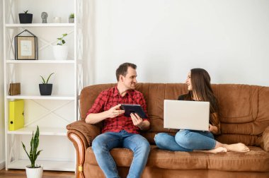 Kanepede oturan genç evli bir çift.