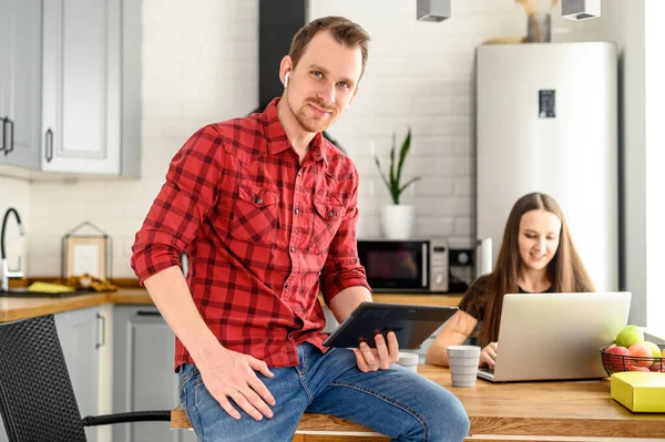 Um tipo com um tablet na camisa marcada — Fotografia de Stock