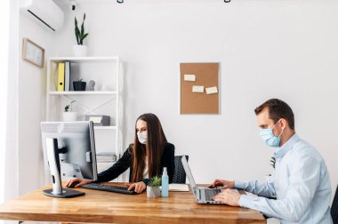 Pandemia sırasında maske takan ofis çalışanları