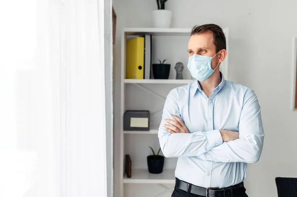 Mannen i en medicinsk mask på kontoret — Stockfoto