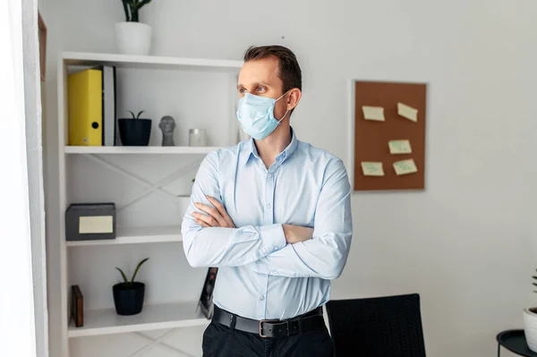 Άντρας με ιατρική μάσκα στο γραφείο. — Φωτογραφία Αρχείου