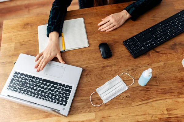 Máscara e desinfetante na área de trabalho, perto do teclado — Fotografia de Stock