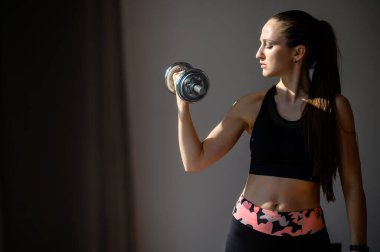 Genç kadın tüm vücudunu evde çalıştırıyor.