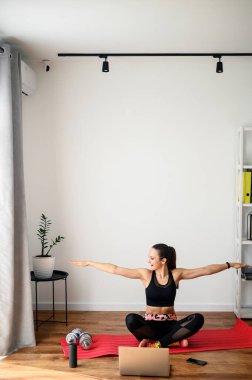 Evde video dersi veren bir kadın spor yapıyor.