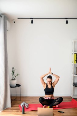 Evde video dersi veren bir kadın spor yapıyor.