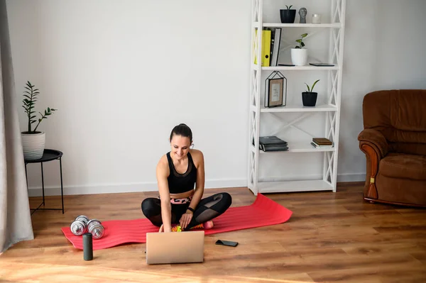 Женщина занимается фитнесом дома с видео-уроком — стоковое фото