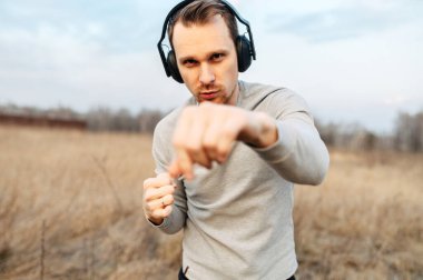 Kulaklıklı genç bir adam spor antrenmanı yapıyor.