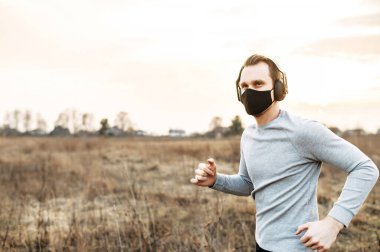 Tıbbi maskeli adam koşuyor.