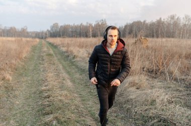 Açık havada kardiyo çalışması. Genç adam koşuyor.