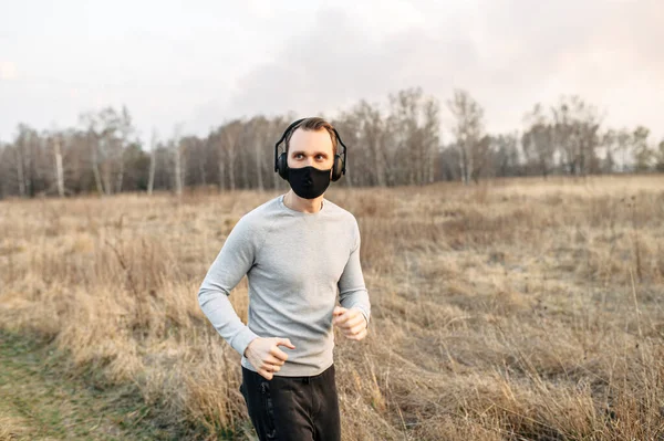 Guy in a medical mask is jogging