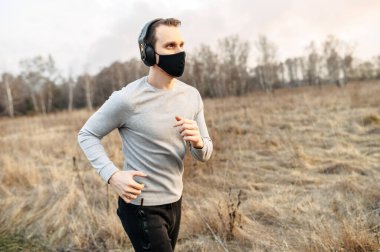 Tıbbi maskeli adam koşuyor.