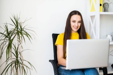 Ev ortamında dizüstü bilgisayarı olan bir kadın.