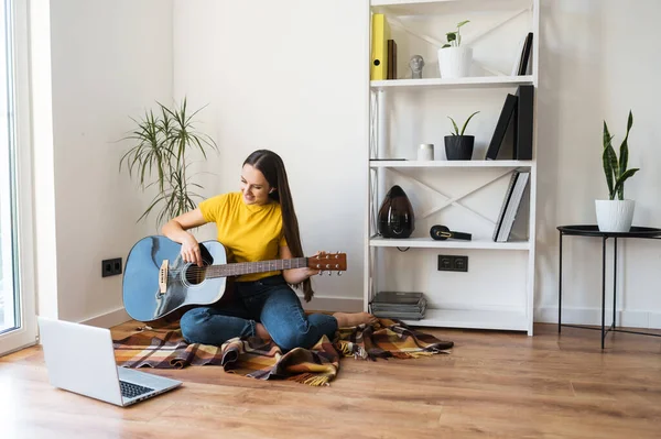 Женщина смотрит видео-урок по игре на гитаре — стоковое фото