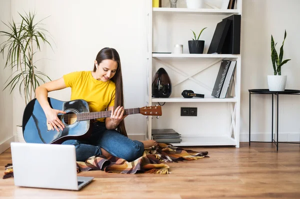 A woman watches video tutorial on guitar playing