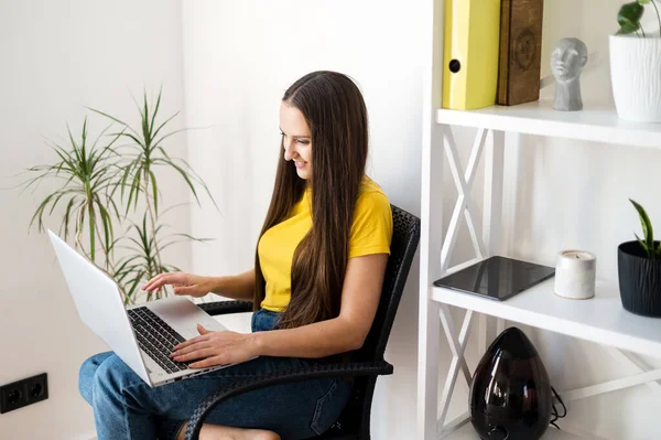 Женщина в уютной домашней атмосфере с ноутбуком — стоковое фото
