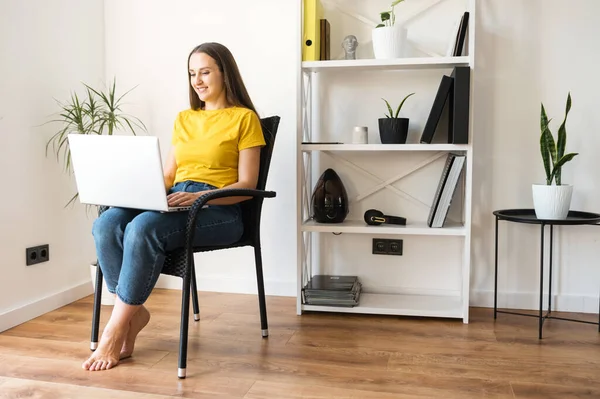 Femme dans une atmosphère confortable à la maison avec un ordinateur portable — Photo