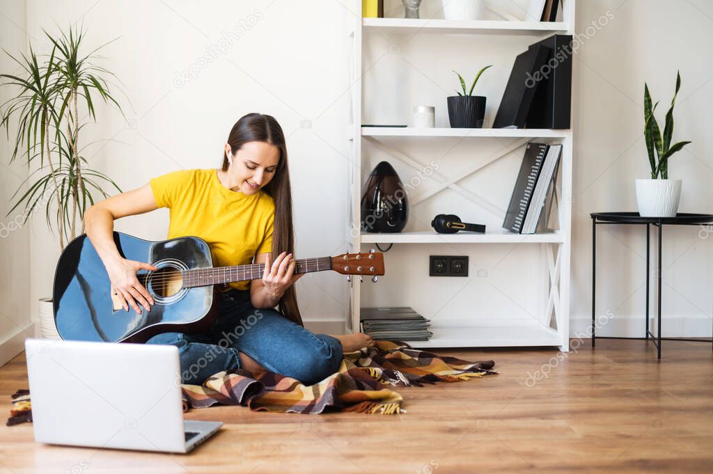 A woman watches video tutorial on guitar playing