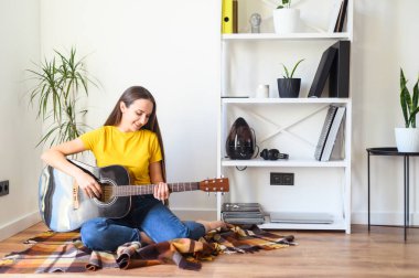 Gitarlı bir kadın boş vakit geçirir.