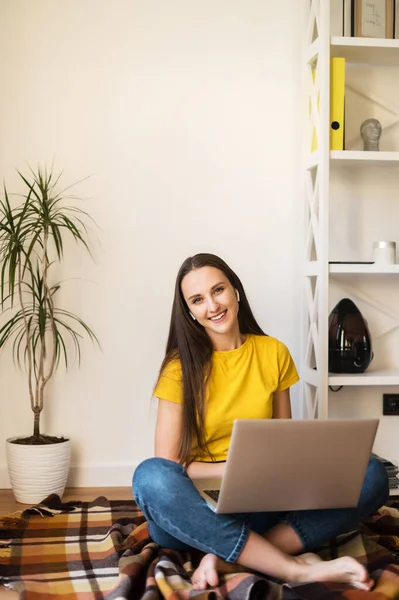 Junge attraktive Frau sitzt mit Laptop zu Hause — Stockfoto