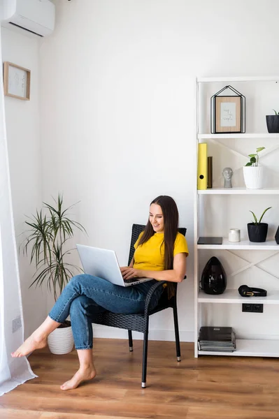 Vrouw in een gezellige huiselijke sfeer met een laptop — Stockfoto