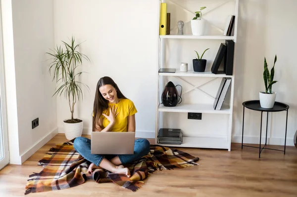 Vrouw in een geel t-shirt communiceert via video — Stockfoto