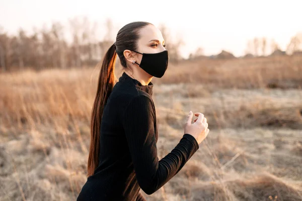 Atractiva mujer de estilo deportivo en una máscara médica — Foto de Stock