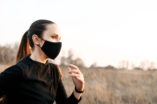 Perempuan dalam pakaian olahraga hitam total berlari di luar ruangan — Stok Foto